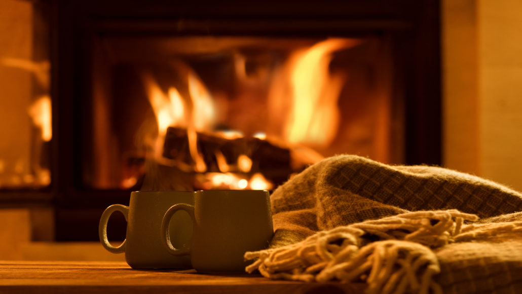 Steam from a cups with a hot cocoa on the fireplace background ...